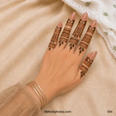 Back hand featuring a simple finger mehndi design with lotus motifs, horizontal bands, geometric panels and small leafy details.