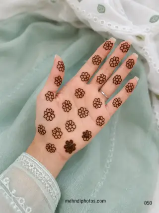 Simple front hand mehndi design featuring small outline flowers scattered evenly across the palm and fingers
