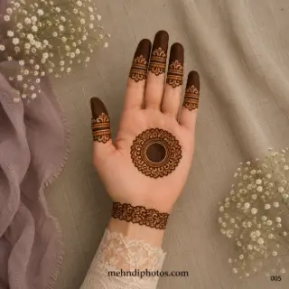 Simple round finger mehndi design with a central tikki mandala, decorated finger bands, floral wrist border and traditional Indian henna details.
