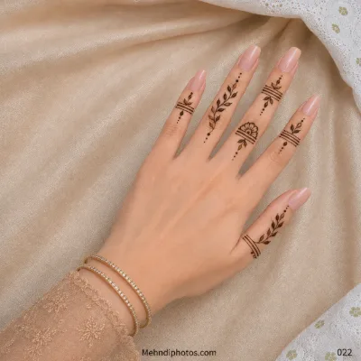 Back hand with minimal leafy finger motifs, fine horizontal line bands, dotted trails and a small half-flower design.