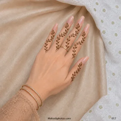 Back hand with a thin and delicate leafy mehndi vine extending along each finger.