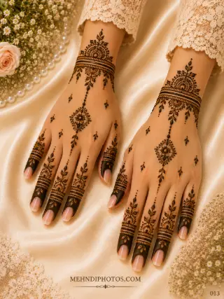 Simple back hand mehndi design on two hands with floral wrist bracelets, diamond-shaped pendant motifs, scattered leaves and decorated fingers.