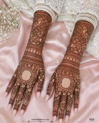 Intricate full arm bridal mehndi design with fine jaal patterns and mandala art on the back of both hands