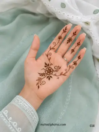 Minimal front hand mehndi design featuring a central flower with curling vines, delicate leaves and small floral accents on the fingers
