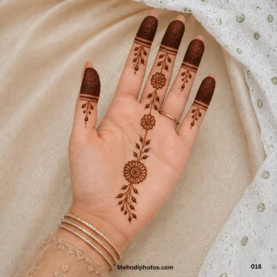 Front hand with dark floral fingertips, hanging leafy branches and a vertical flower-and-leaf vine across the palm.