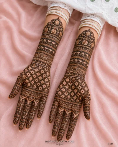 Engagement full hand mehndi design featuring a delicate floral jaali pattern with detailed wrist bands and traditional finger motifs.