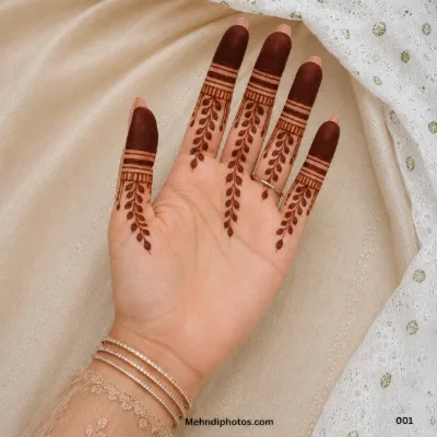 Front hand with a simple finger mehndi design featuring filled fingertips, horizontal bands and delicate leafy vine patterns.