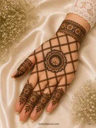 Front hand mehndi design featuring a central lotus mandala, diamond-shaped leafy jaali, floral wrist bracelet and matching finger bands.